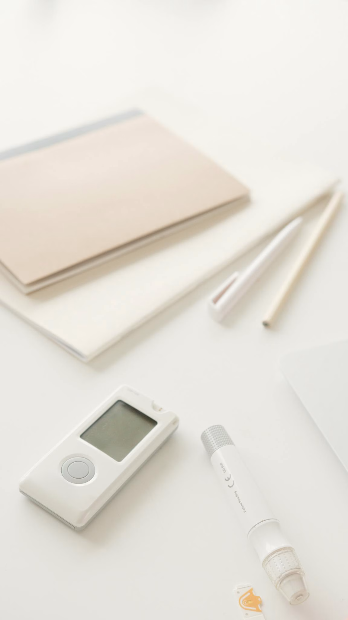 Close up of a glucometer and lancet pen on a desk, ideal for diabetes management visuals 